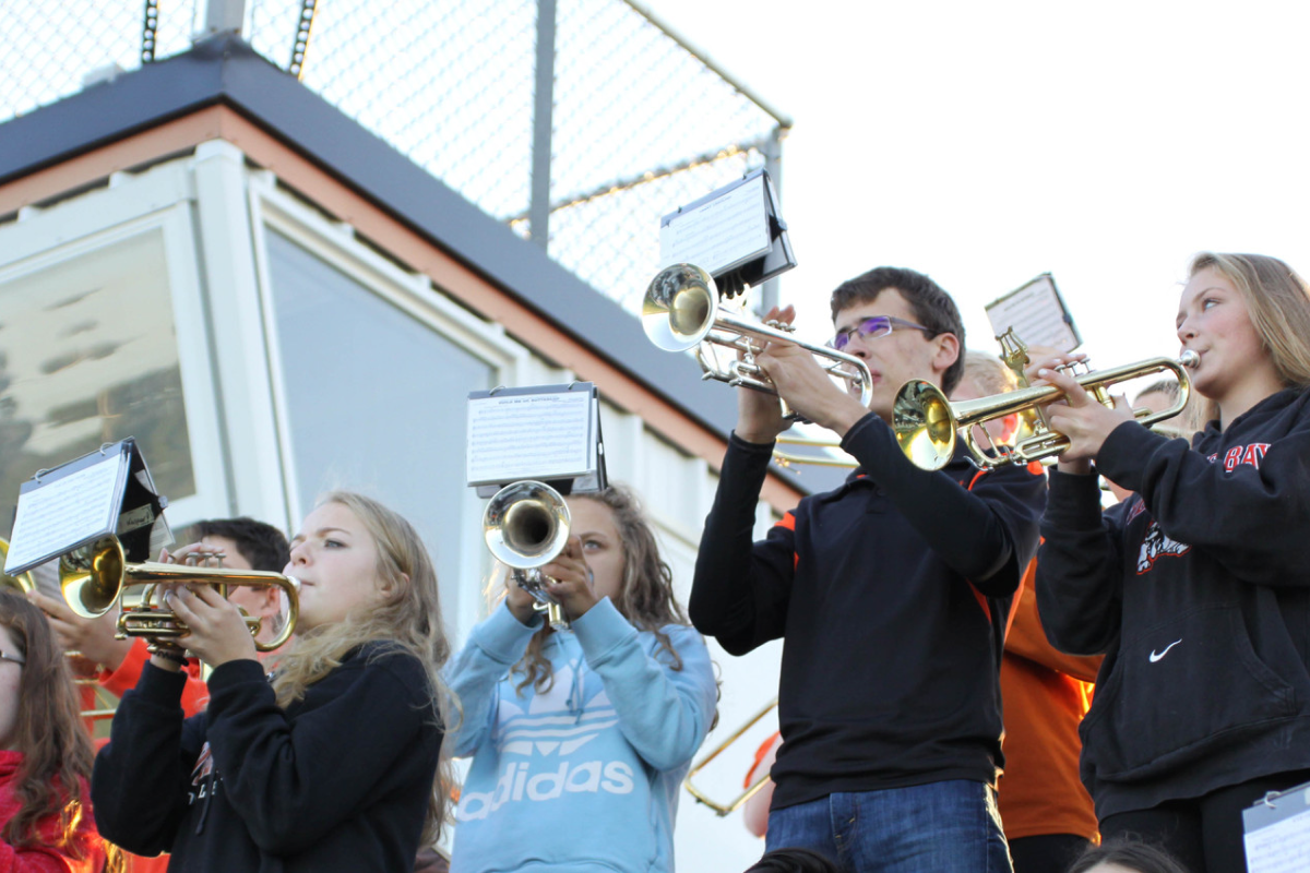 students plays music instruments outside in stands